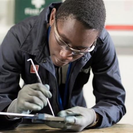 A National Grid representative is investigating a small piece of machinery against an out of focus background 