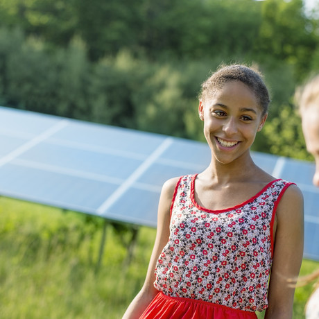 Young women with solar panel in the background