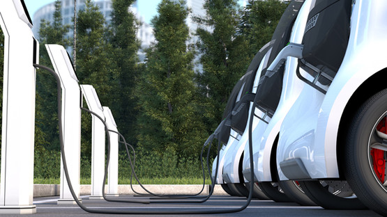Row of white electric cars charging at a charging station