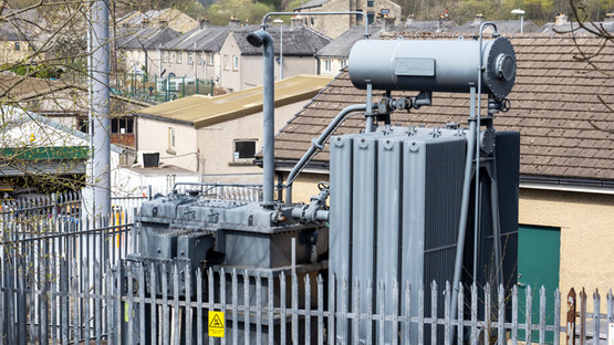 Close-up of a electricity distribution substation next to a house