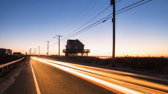 Blurred headlight of car on road by the shore at dawn