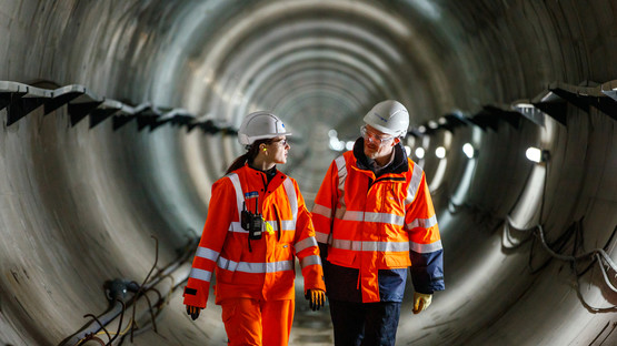 Man and woman wearing PPE walking through Humber Tunnel