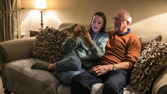 Girl and elderly man looking at a phone.jpg
