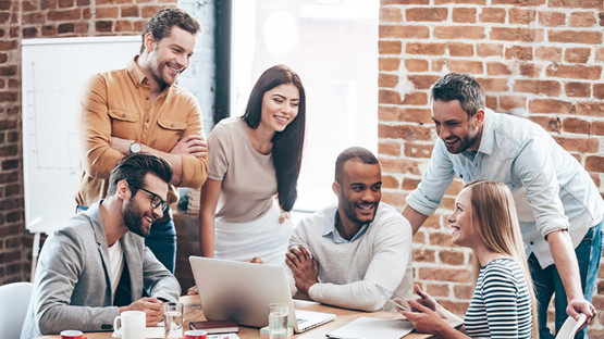 People standing and sitting around a meeting room table