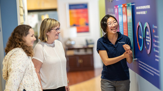 National Grid colleague talking to mother and daughter at our Sustainability Hub in Worcester, US