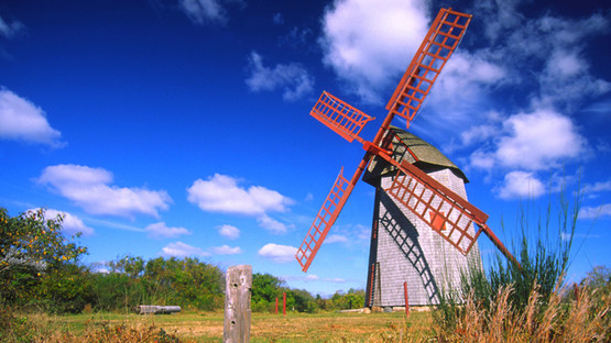 Windmill in a green field against a blue summer sky