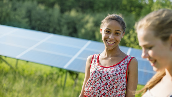 Young women with solar panel in the background