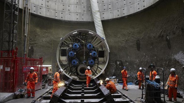 Several Gas industry workers using a tunnel boring machine