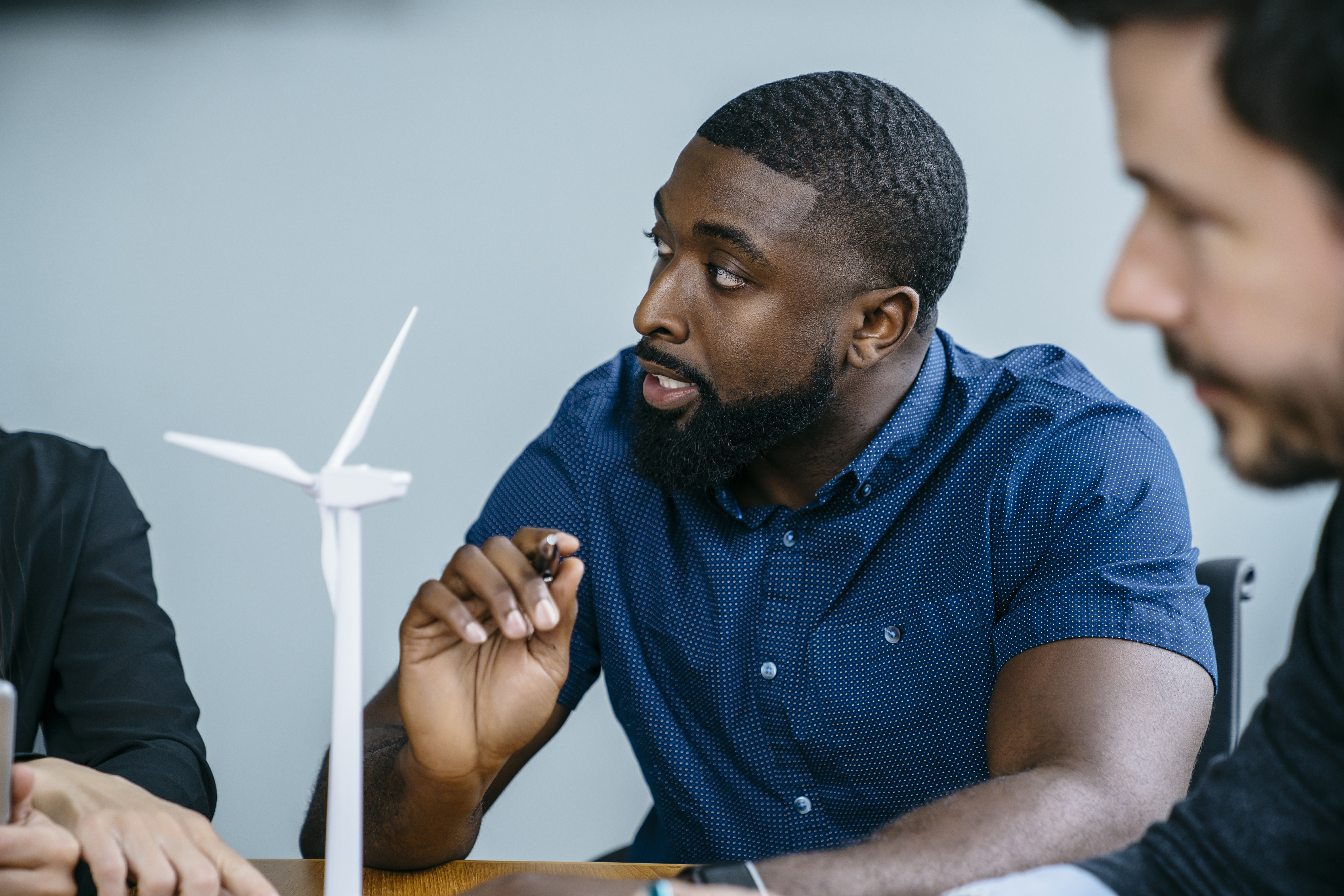 Man in discussion with miniature wind farm