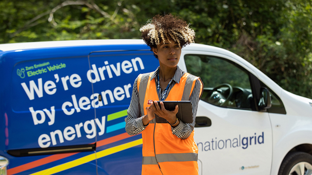 Woman wearing high-vis vest in front of National Grid EV van - used for launch of National Grid's Responsible Business Charter